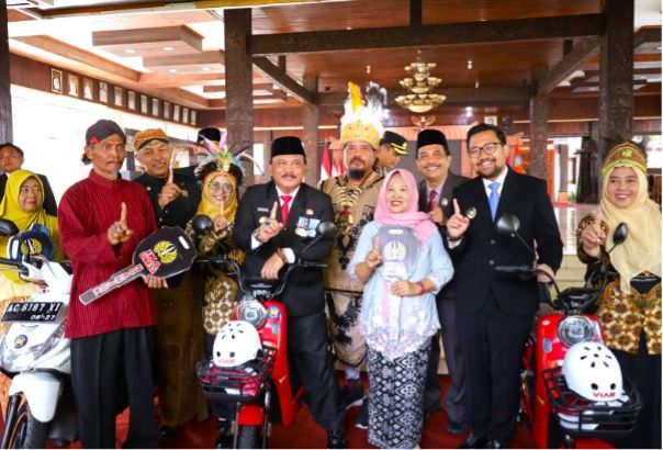 Ketua Harian IKA Unesa, pengurus IKA Unesa Nganjuk bersama GTT penerima sepeda motor dan sepeda listrik.