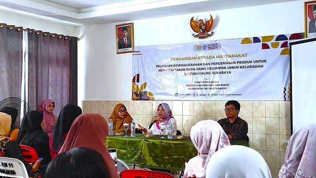 Koorprodi S-3 Manajemen UNESA (tengah) memberikan penguatan dalam pelatihan kewirausahaan dan pengemasan produk di Balai Kelurahan Sawunggaling Surabaya.