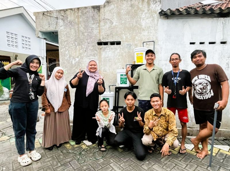 Mahasiswa KKN-T Unesa dan warga berpose di depan IPA yang dibangun dari kerja sama dan kesadaran lingkungan berkelanjutan.