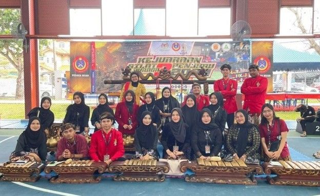 Mahasiswa Prodi S-1 Pend Bahasa dan Sastra Jawa Unesa mengajarkan mahasiswa Malaysia cara bermain gamelan dalam program pertukaran internasional.